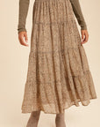 A flowy long skirt in cheetah print design featuring shades of brown and tan. Sheer top layer and fully lined. Pictured on model. On model it hits just above her ankle. Paired with a body suit and boots.