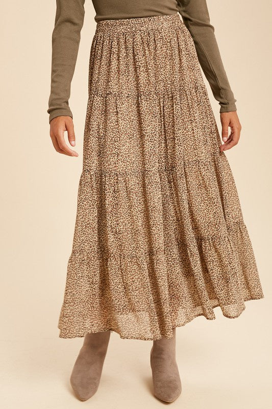A flowy long skirt in cheetah print design featuring shades of brown and tan. Sheer top layer and fully lined. Pictured on model. On model it hits just above her ankle. Paired with a body suit and boots.