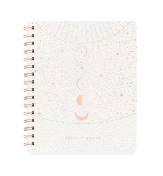 white spiral bound planner with gold foil design of moon phases and stars