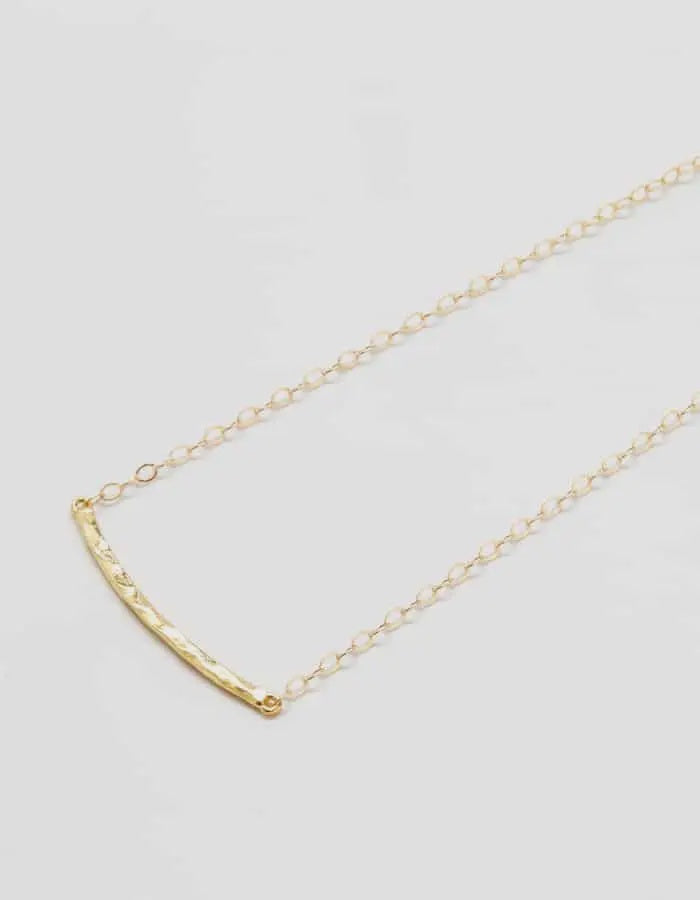 The Gold Hammered Curved Bar Necklace by Admiral Row