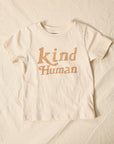kid's tee shirt, bone color with tan retro font which reads "kind human"